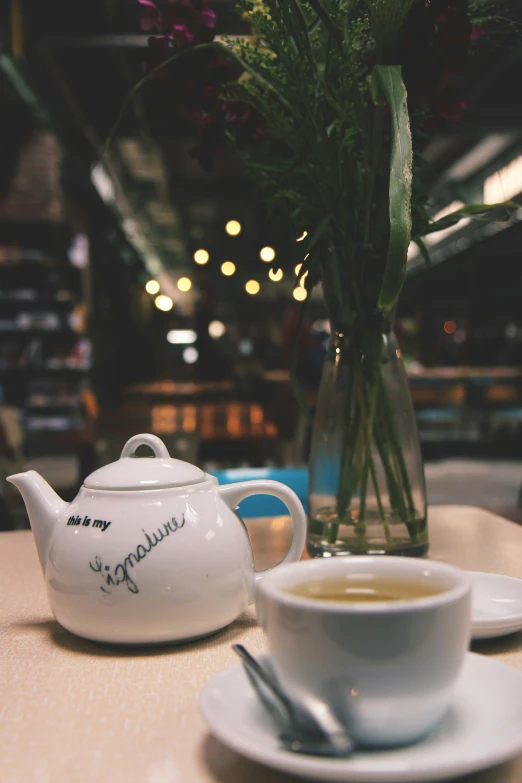 there is a coffee pot and a cup next to a teapot