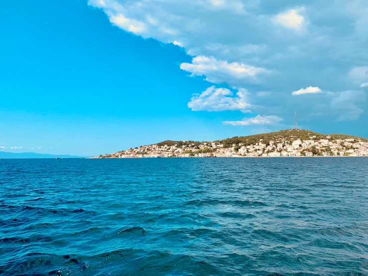 a body of water next to a mountain and a sky