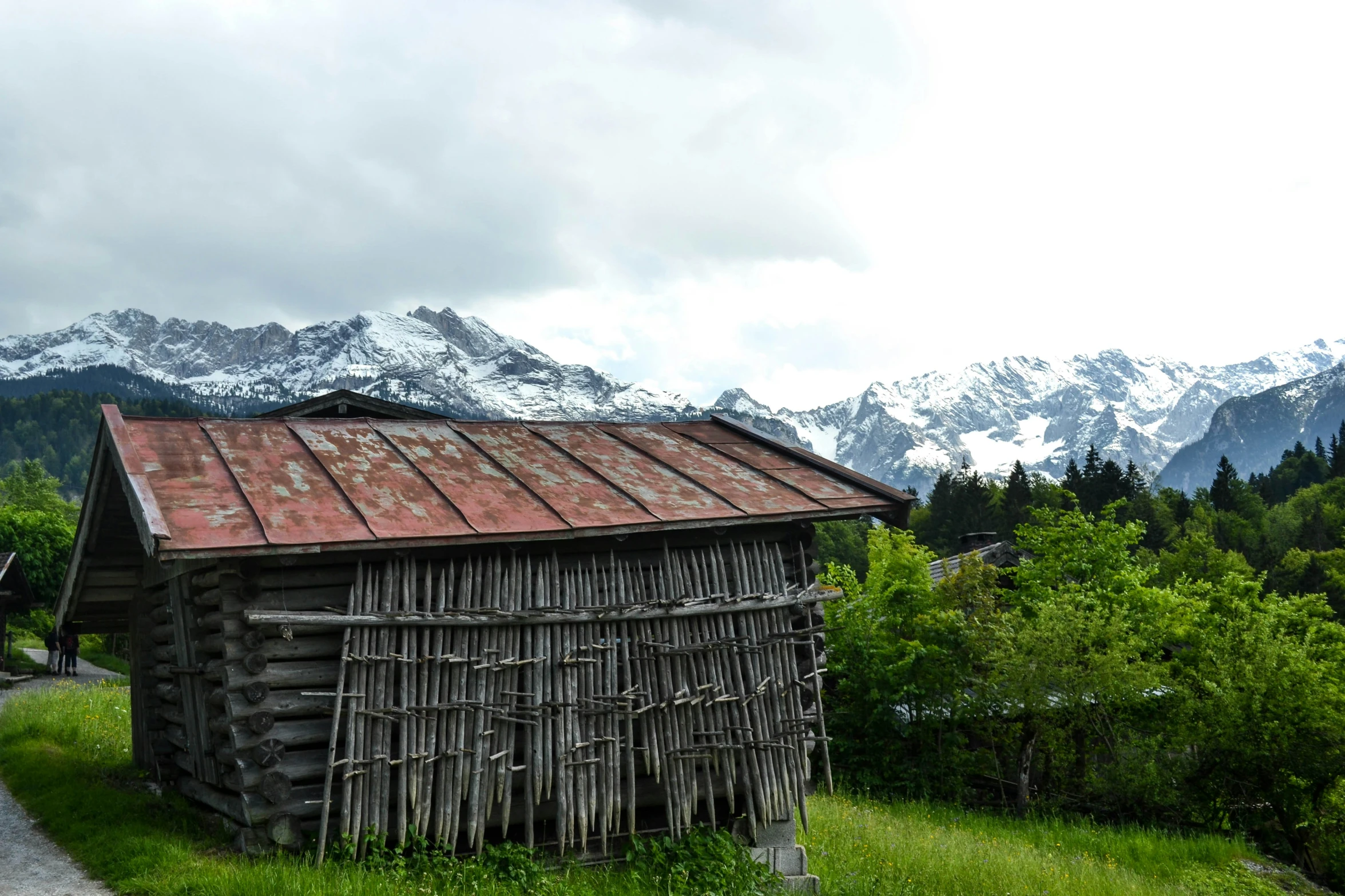 an old building with rust on the roof surrounded by mountains