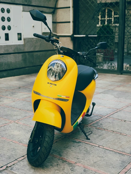 a bright yellow scooter is parked outside a building