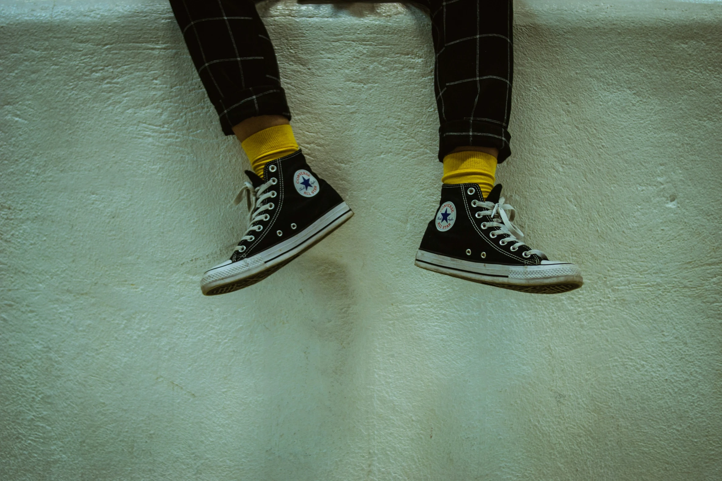 a person with yellow socks is on a step stool