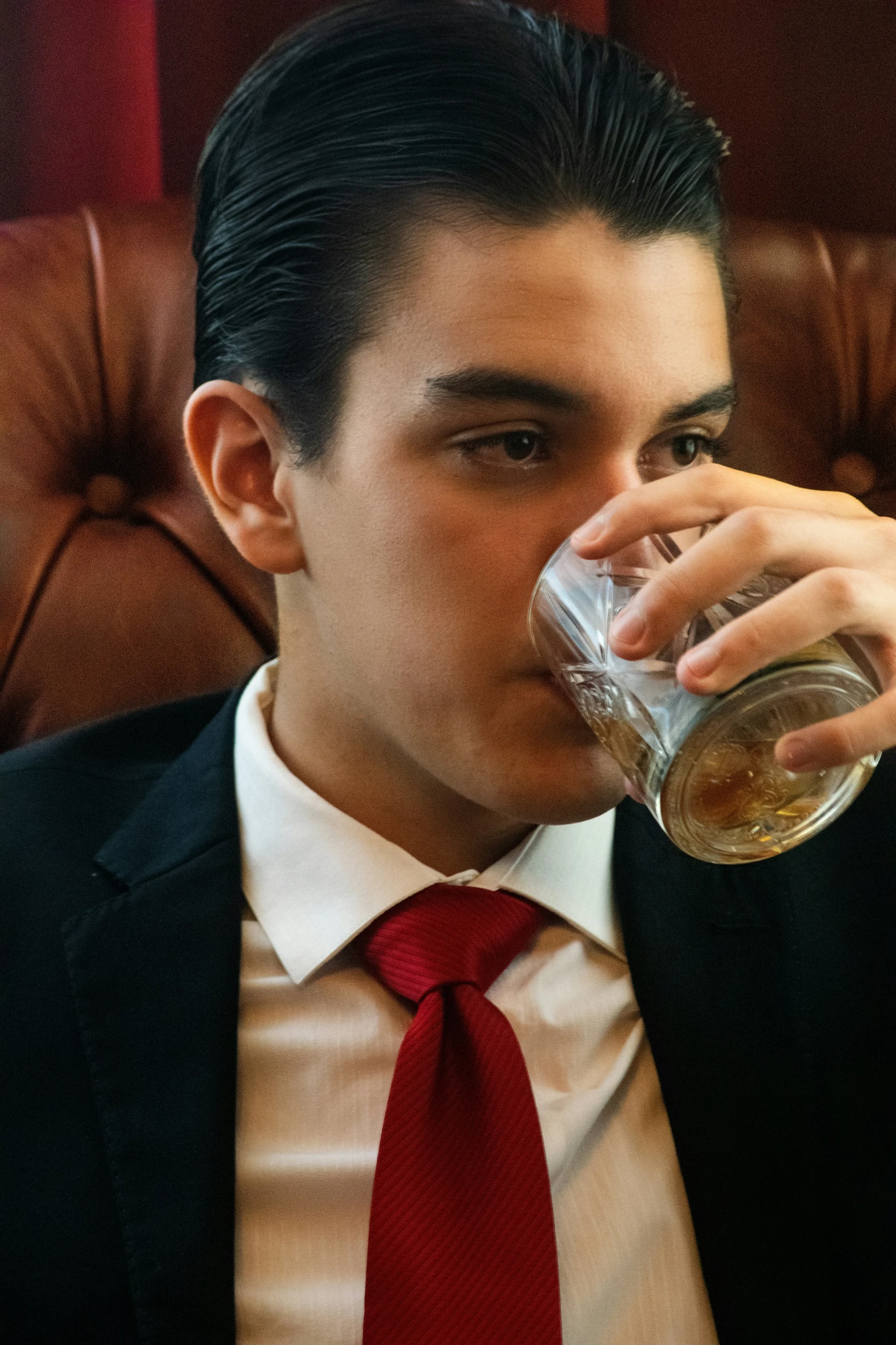 man in business suit drinking from a glass