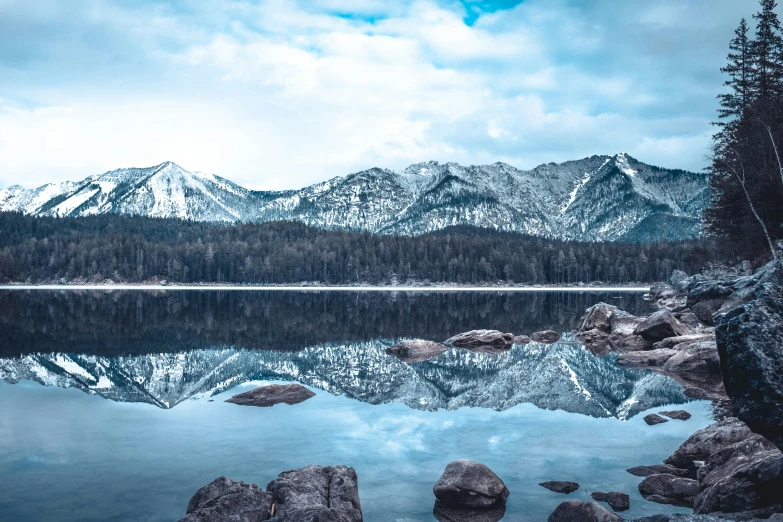 the mountains are in the distance and reflecting in the water