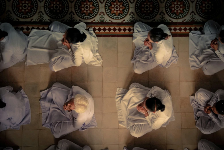 six people dressed in white sitting on the floor