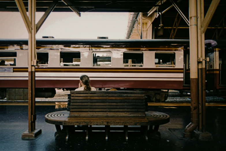 the girl sits on the bench in the station