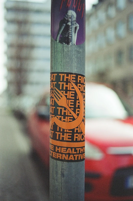 a sticker on a pole is showing an image of a skeleton and a human being