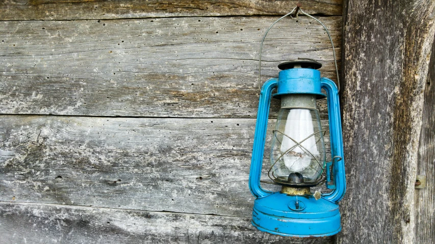 an old, rusty, blue lamp attached to a wall