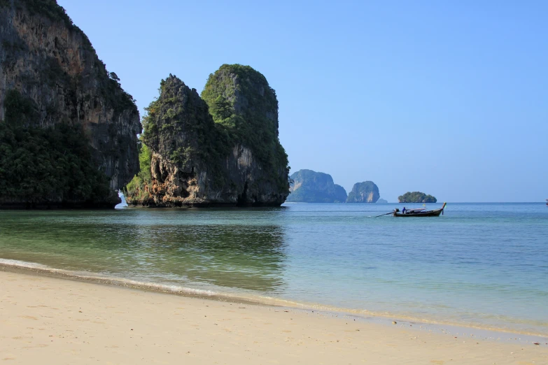 a small boat out on the water near rock formations