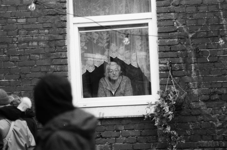 black and white pograph of two people looking in window