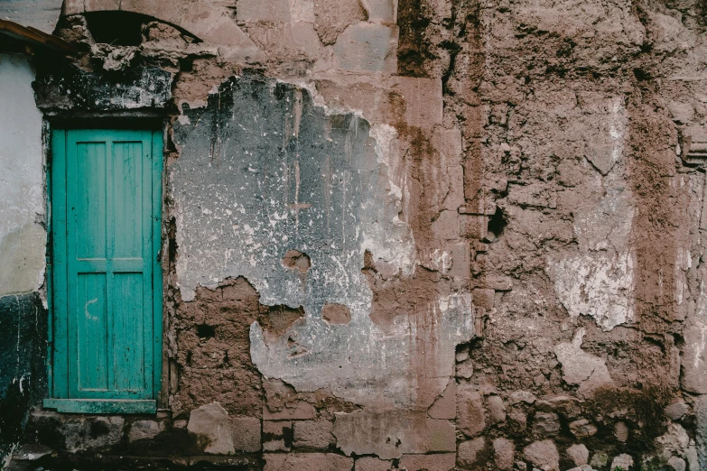 an old building with peeling paint and wood shutters