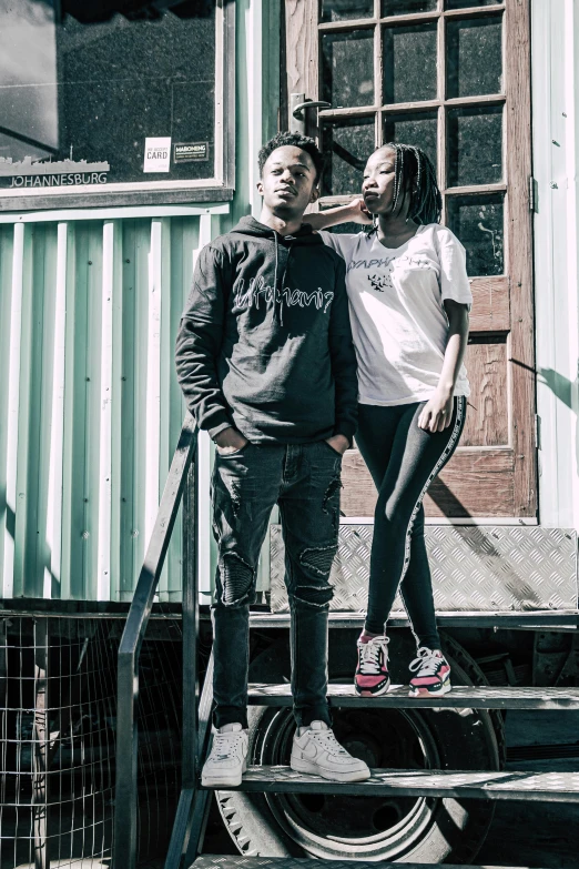 two s pose for a picture on steps outside of an old building