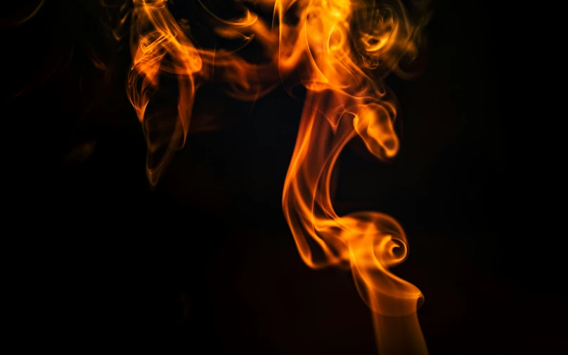 orange and yellow smoke is shown as seen against a black background