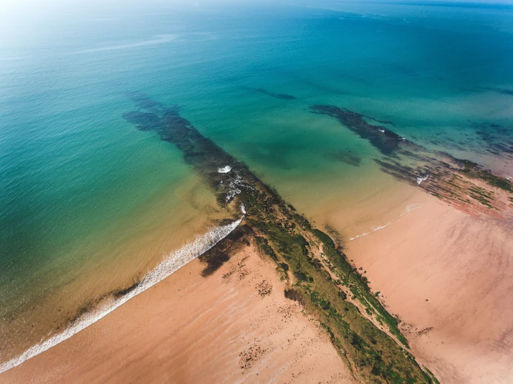 an aerial s of a beach with clear waters and some trees