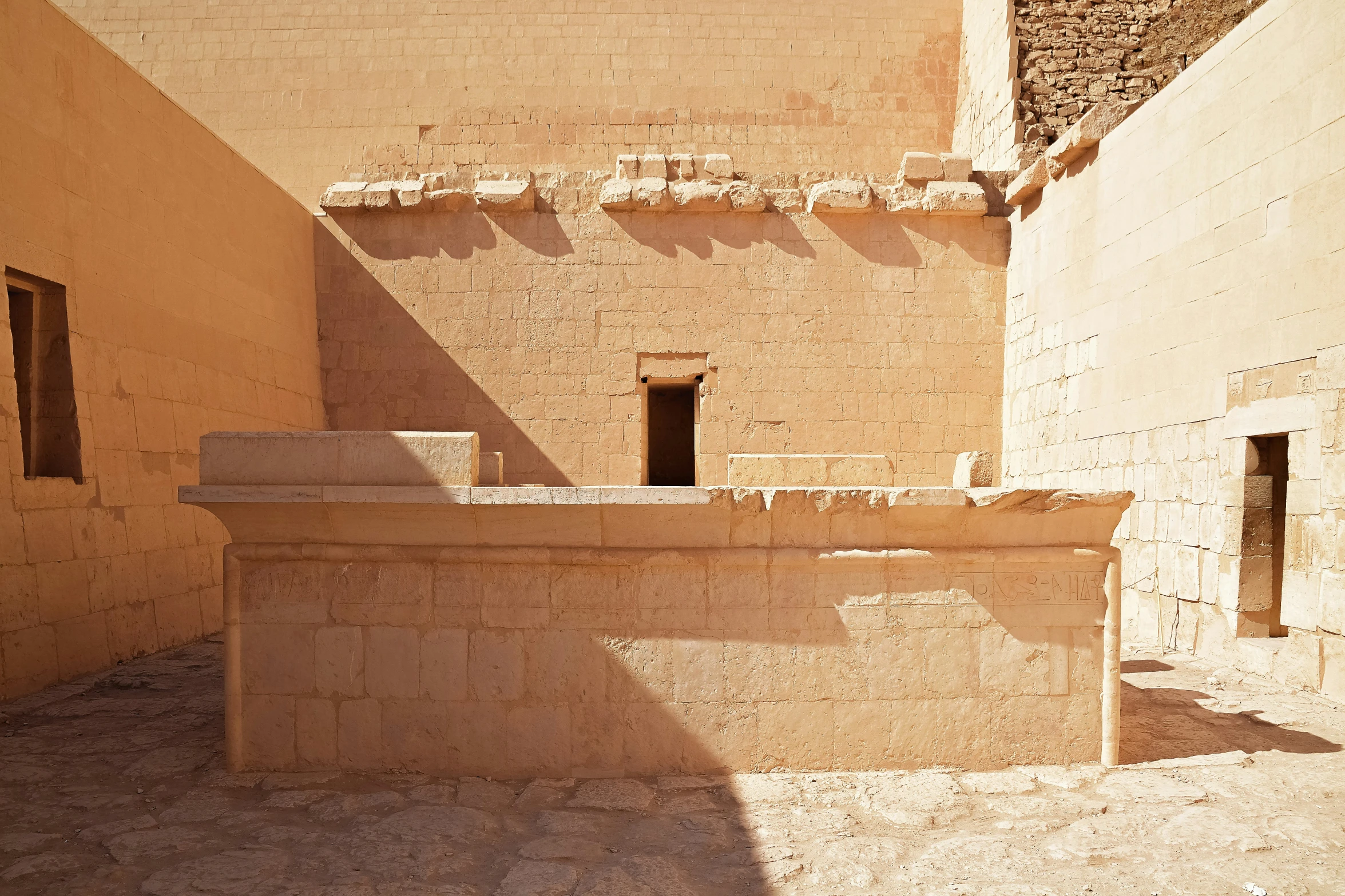 a stone water fountain surrounded by building in the sun