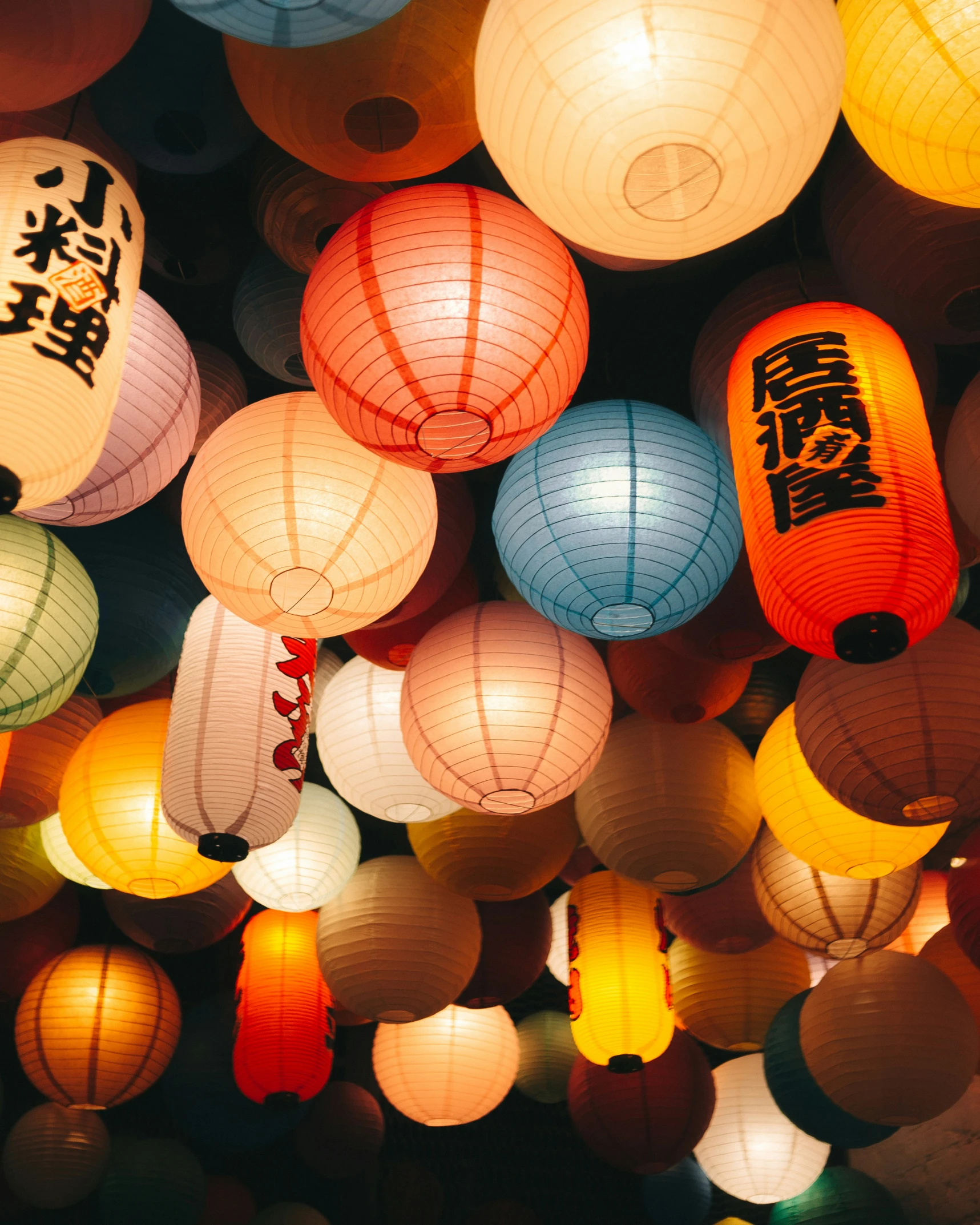 large number of paper lanterns floating in the air