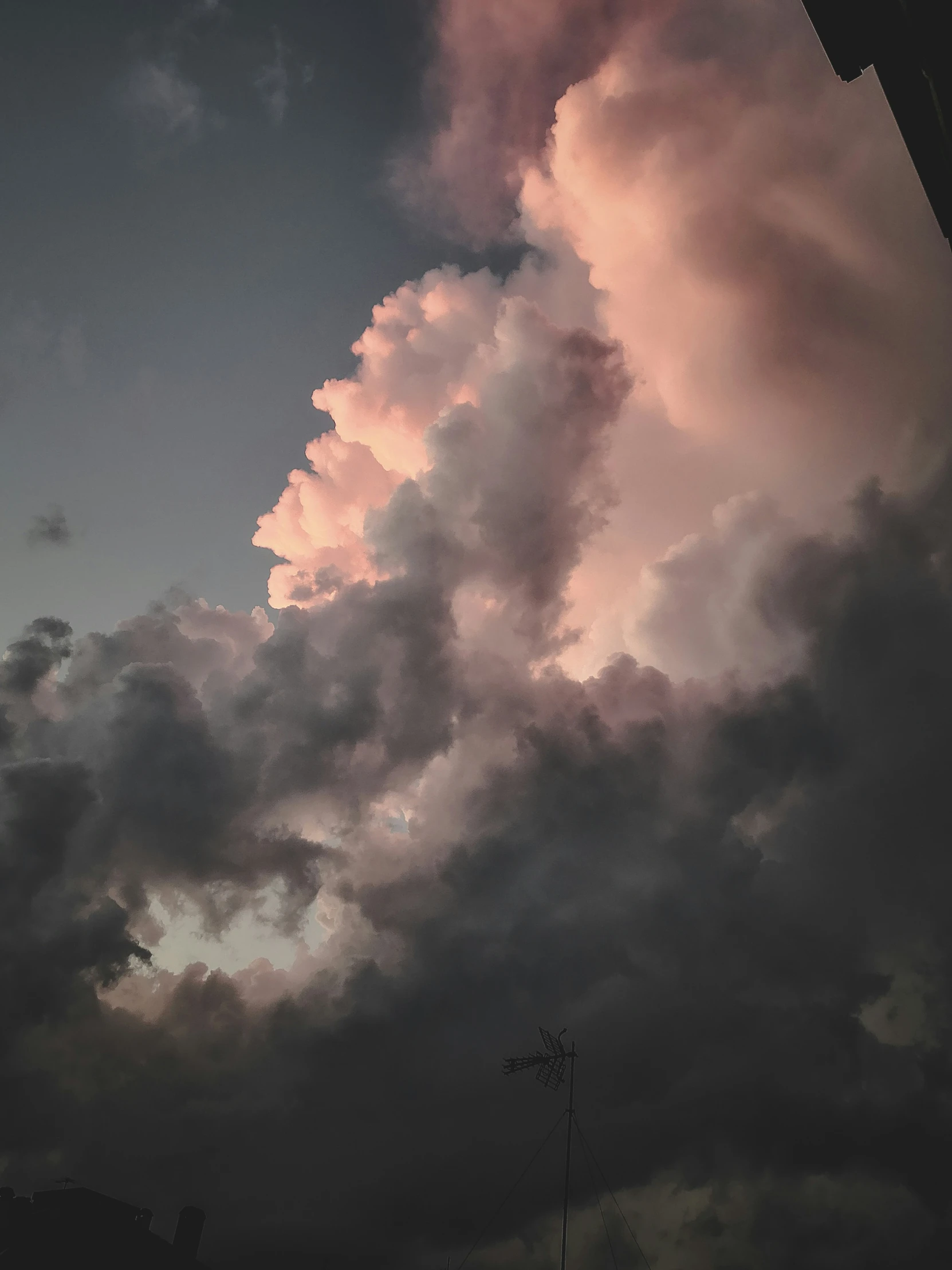 a plane flying in the sky with some clouds around