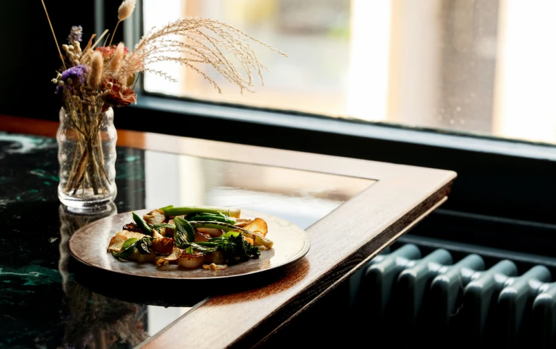 plate of food sitting on a table with a window behind it