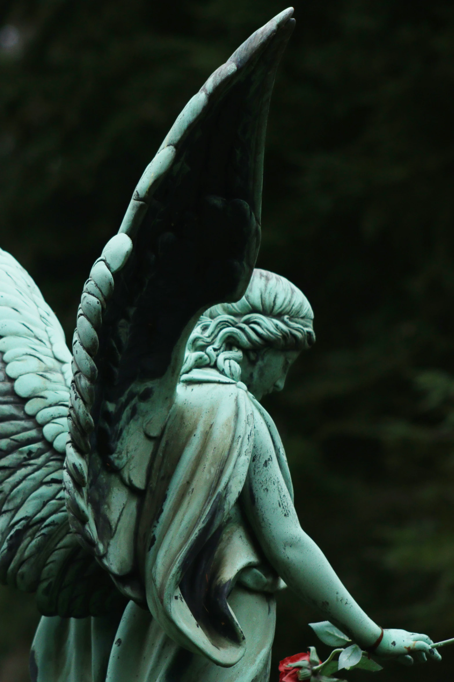 a statue with an angel holding a rose on top of it