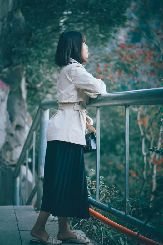 woman looking at the jungle while standing on a walkway