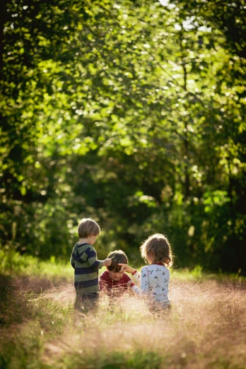 three young children are standing in the grass