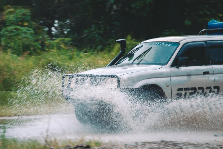 there is a van driving down a muddy road