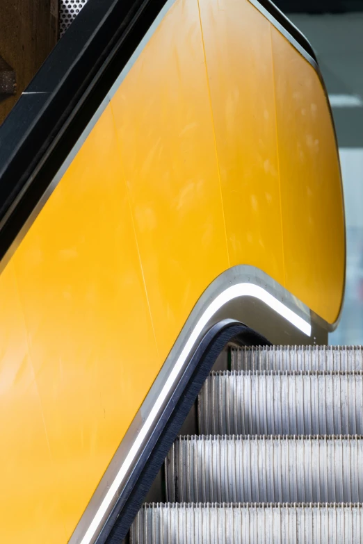 escalator with yellow and black paint on the upper half