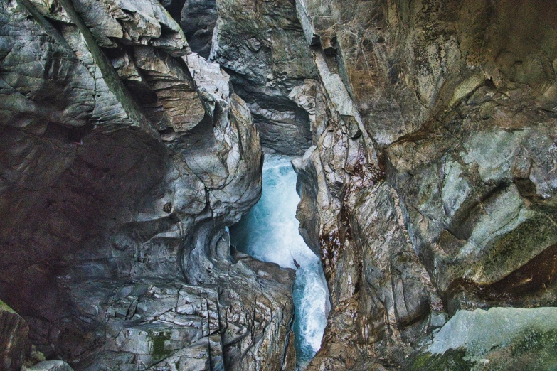 a frozen river flowing between rocks in a canyon