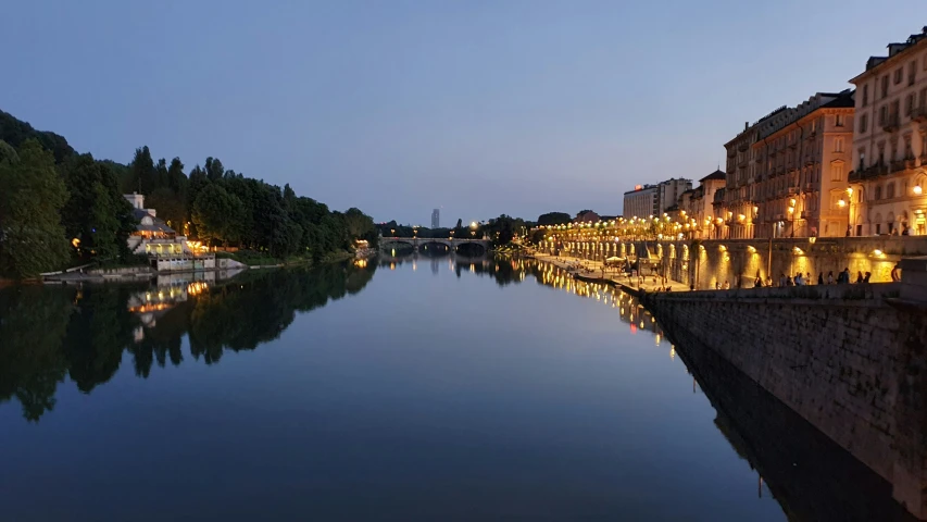 a lake next to several buildings with trees on the side