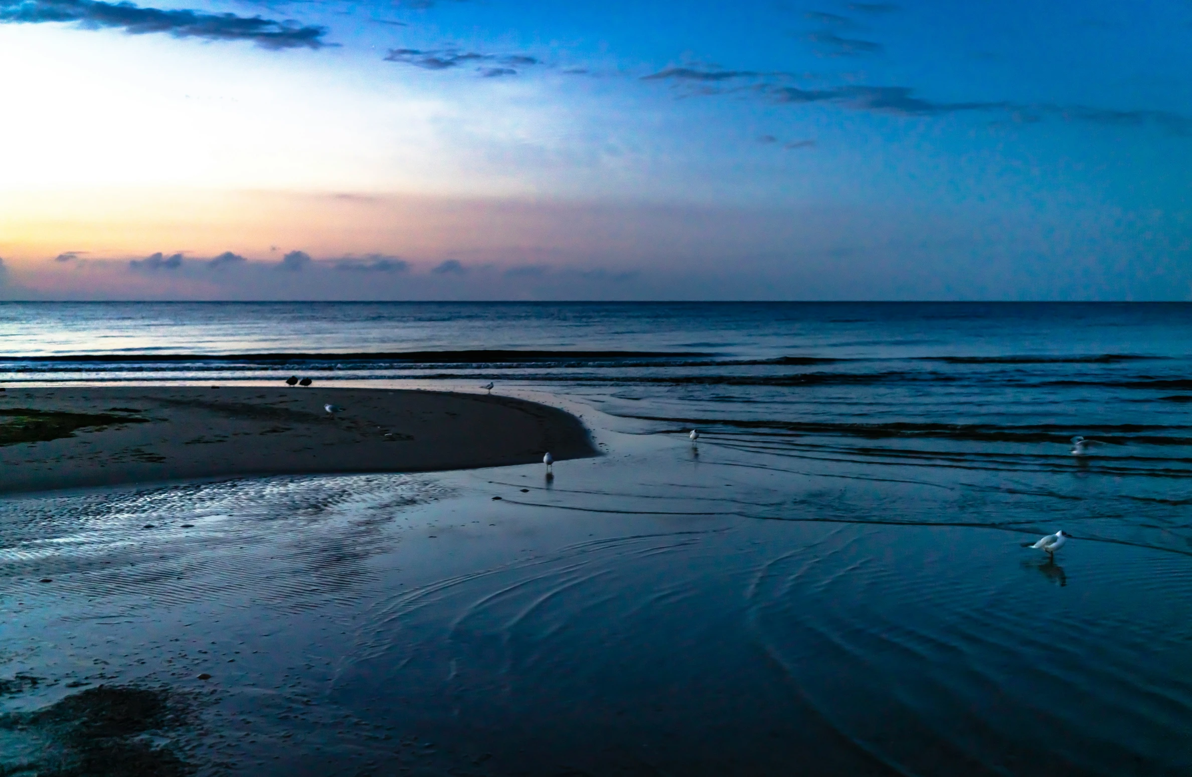 the blue water is reflecting sun and clouds