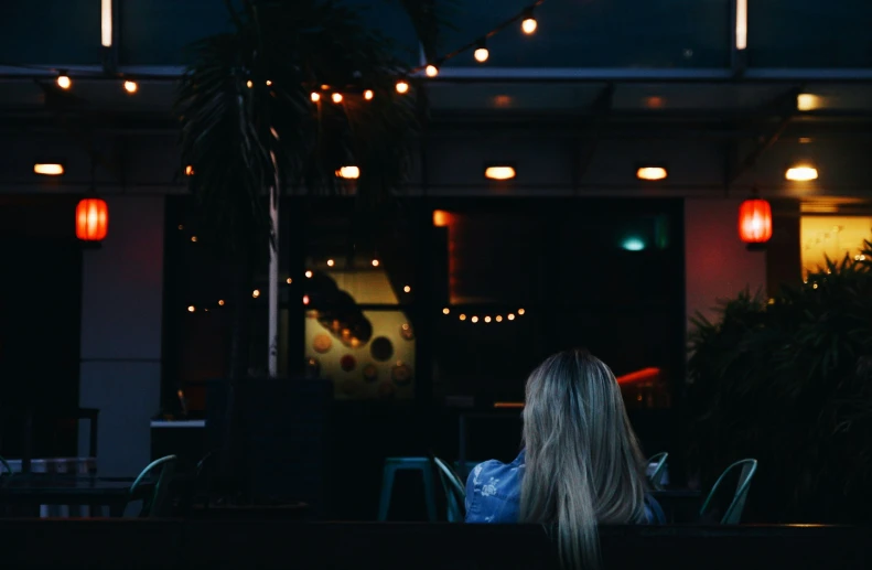 a woman that is sitting in front of some chairs