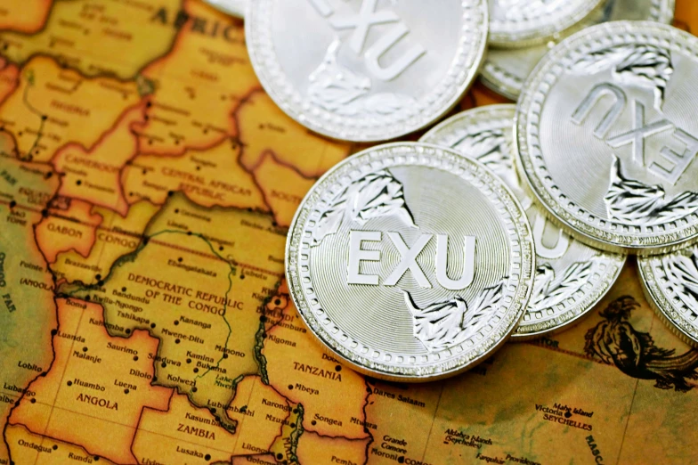 four new twentypen silver pound coins placed on top of a map