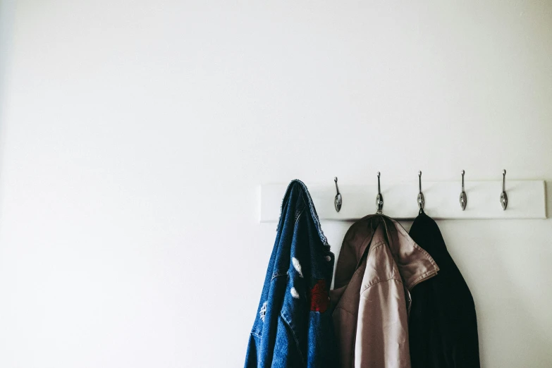 clothes and coats hanging on hooks on the wall