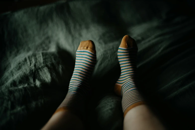 the feet of a person who is sitting on the bed