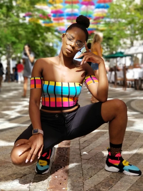 a woman in a colorful shirt holds up a phone