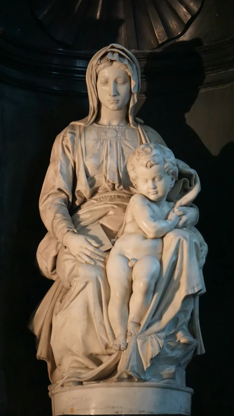 the statue of mary of lounging is next to a clock