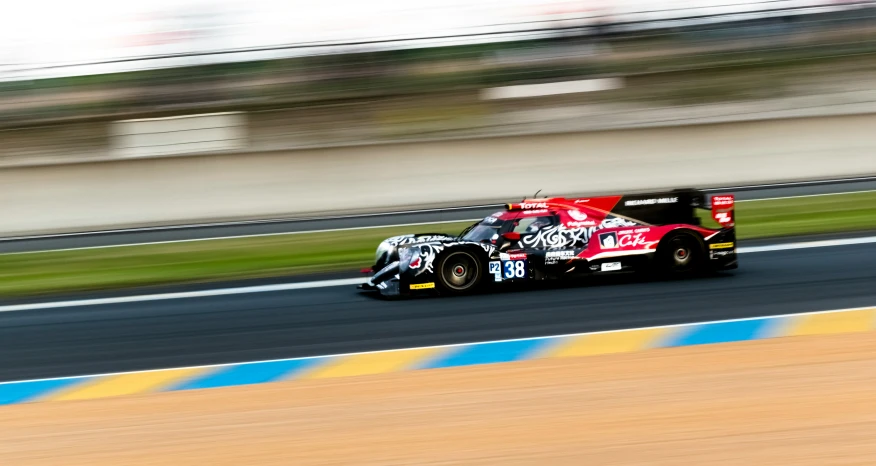 a race car driving on the racetrack with another car behind it