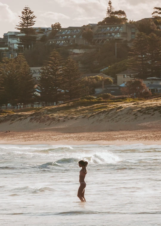 a man standing in the ocean with his surf board