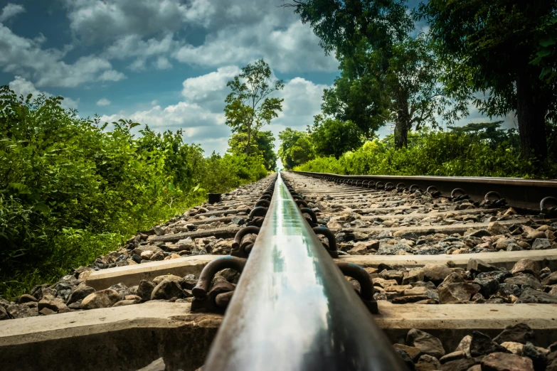 an object is pictured from the middle of a long rail on a railroad track