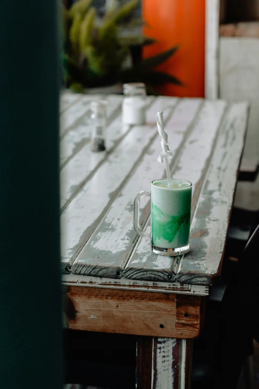 a green cup that has some straws in it