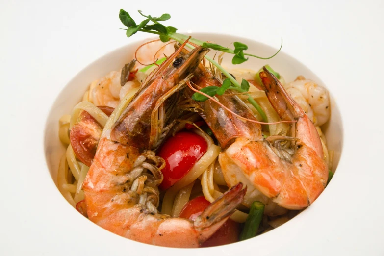 a white bowl filled with shrimp and pasta