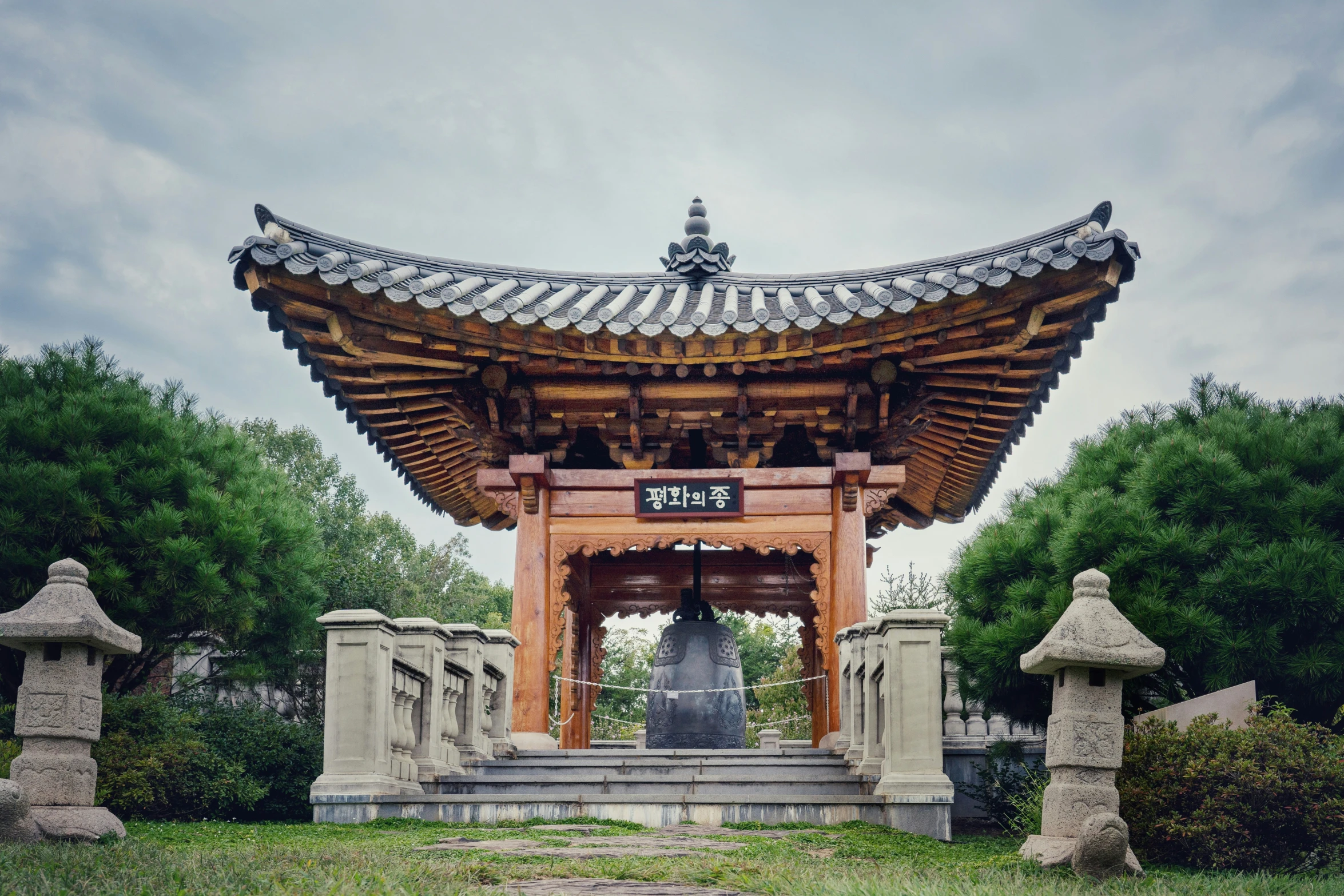 an ornate wooden structure in the middle of a green field