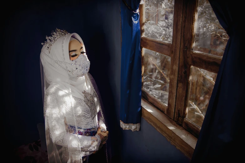 a veiled mannequin is standing in front of an open window