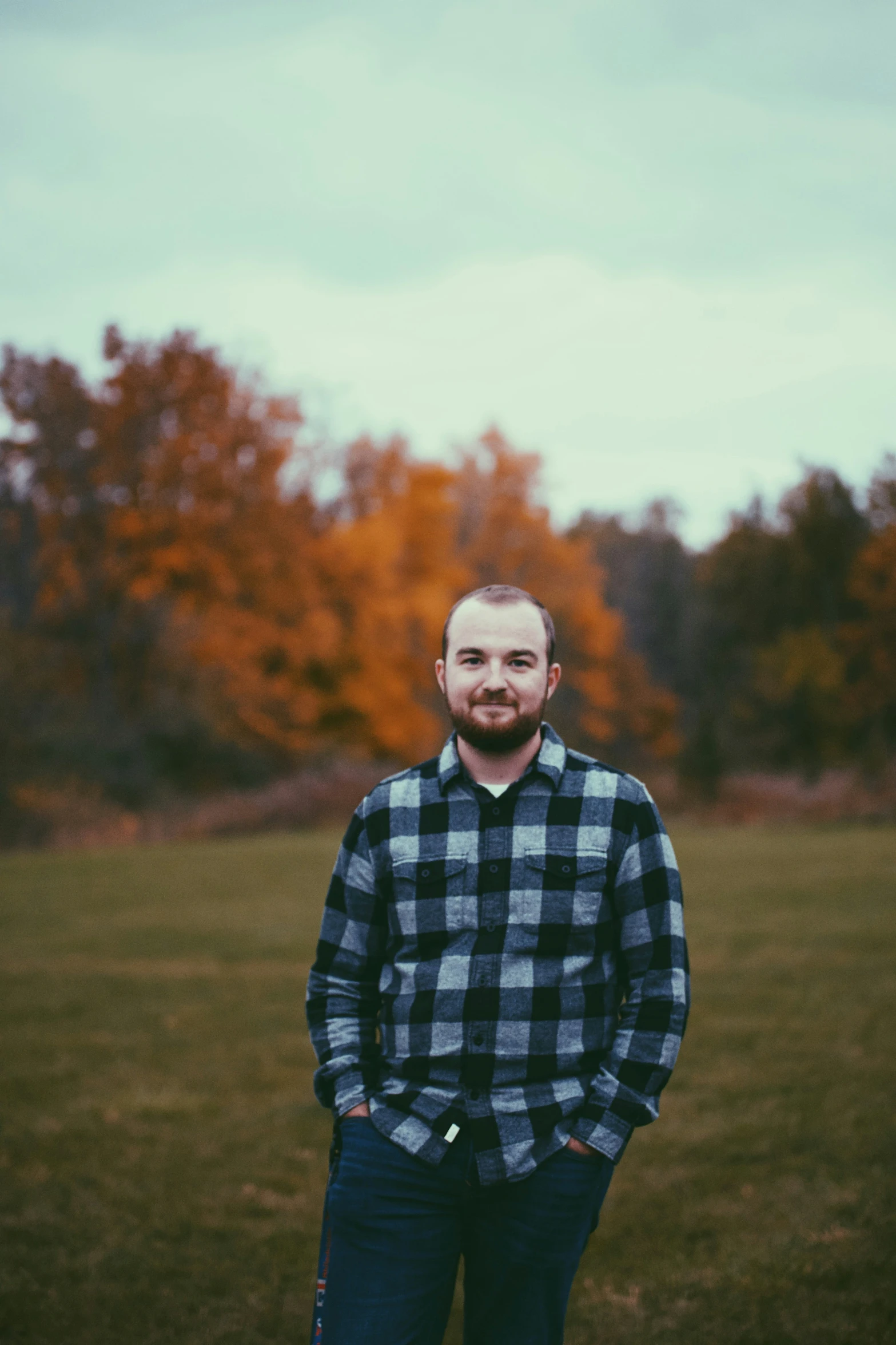 a man stands in a field with his hands on his hips