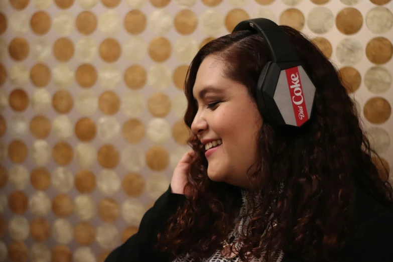 a girl with red hair wearing a pair of black headphones and a polka dot wallpaper