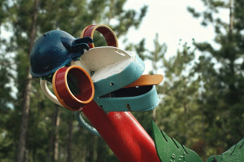 some little colorful things sitting on top of a red pipe