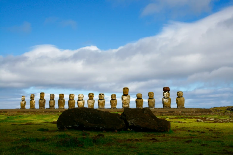 several moai statues lined up in the field