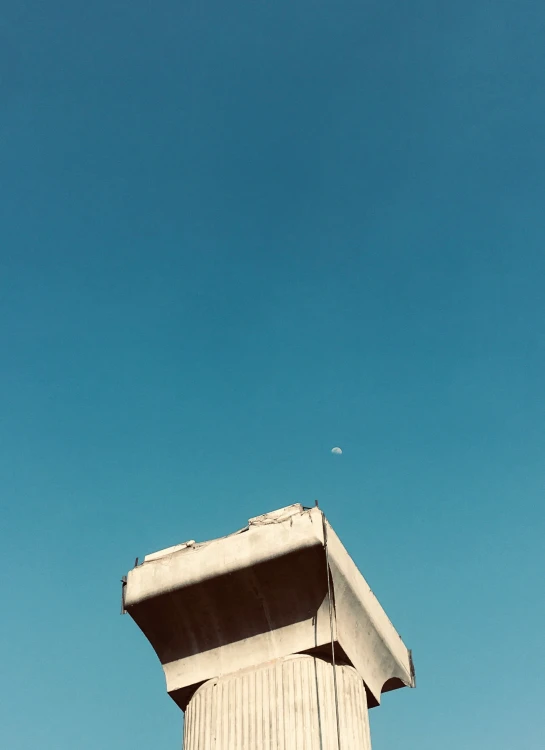 the top of a tower with a bird flying overhead