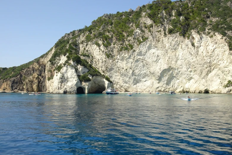 boats are sailing near the cave on the sea