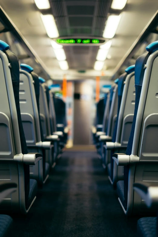 empty seats on a long train with lights on