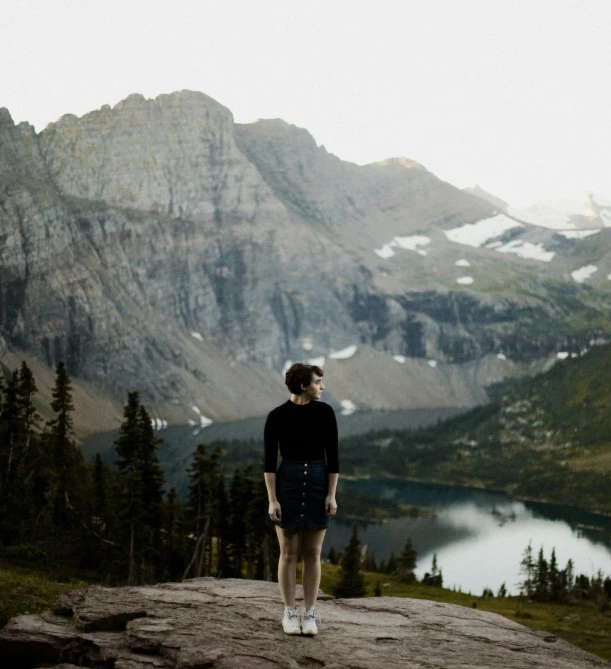 a woman stands on the edge of a rocky mountain